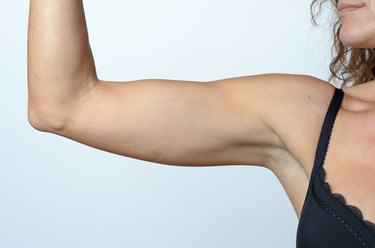 Middle aged woman showing flabby arm