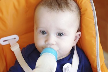 baby eats from small bottle