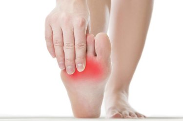 Pain in the foot. Massage of female feet. Pedicures. Isolated on white background.