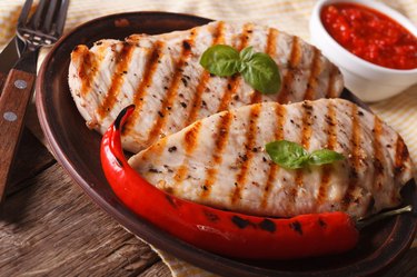 Grilled chicken breast and chili pepper on a plate horizontal