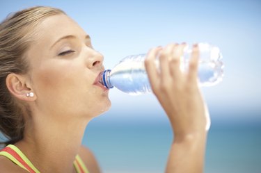 Woman drinking water bottle outdoors