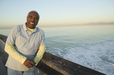 Portrait of a mature man leaning against railing on a bridge