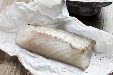 Raw fish fillet, cod on greaseproof paper