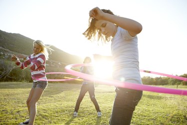 Teenage girls hula-hooping together