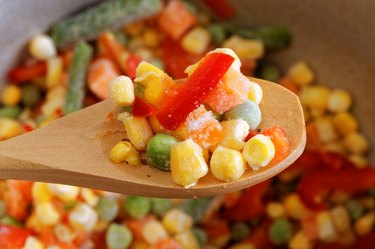 Closeup spoon with frozen mixed vegetables