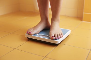 Pair of female feet on a bathroom scale