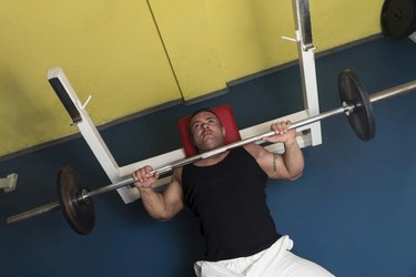 Bodybuilder In Gym Exercising On The Bench Press