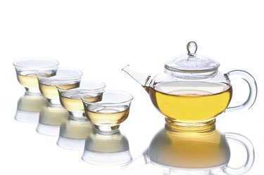 Four cups of tea and a teapot.