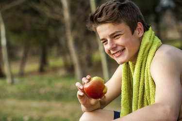 Teen eating apple after ecercise.