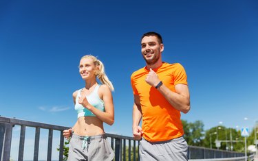 smiling couple running at summer seaside