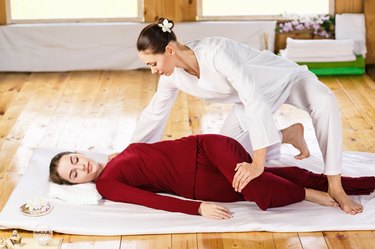 Woman getting thai stretching massage