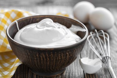 Whipped eggs in a bowl with whisk on a countertop