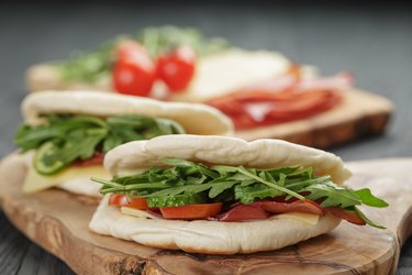 rustic sandwiches with ham arugula and tomatoes in pita bread