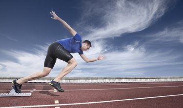 Young athlete launching from a starting block