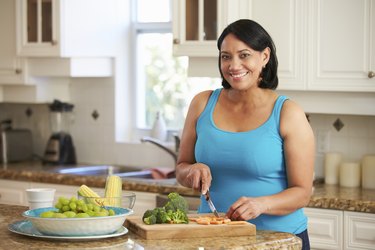 Overweight Woman Preparing Vegetables In Kitchen