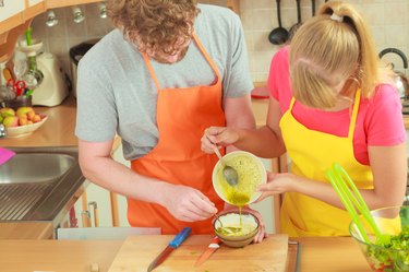 Couple preparing fresh salad dressing