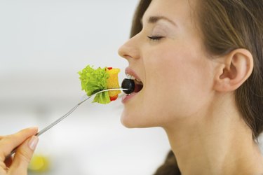 Young woman eating fresh salad