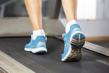 Woman running on treadmill in gym.