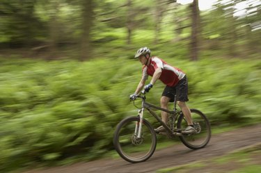 Male cyclist on track in countryside