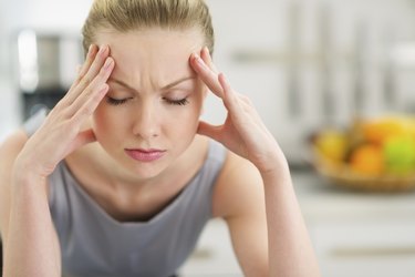 Portrait of stressed young housewife in modern kitchen