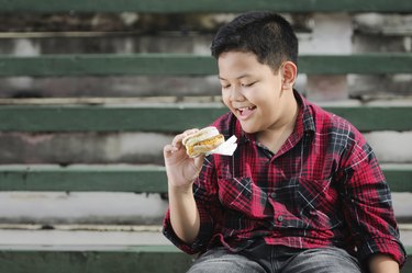 asian boy holding a sandwich