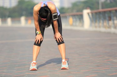 tired woman runner taking a rest after running hard