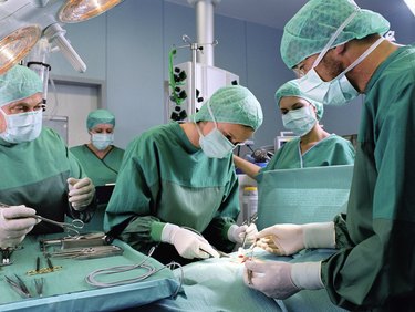 Group of surgeons working in operating theatre