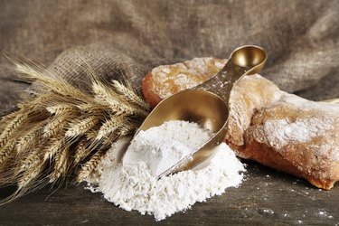 The wholemeal flour in scoop on wooden table