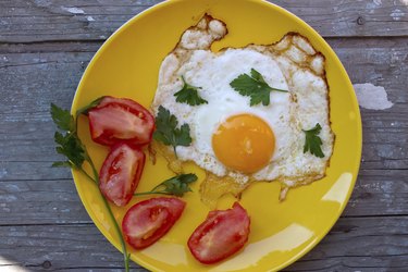 Scrambled eggs with tomato in a yellow plate
