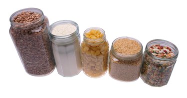 Jars in row, filled with beans, grain, breakfast cereal, and flour