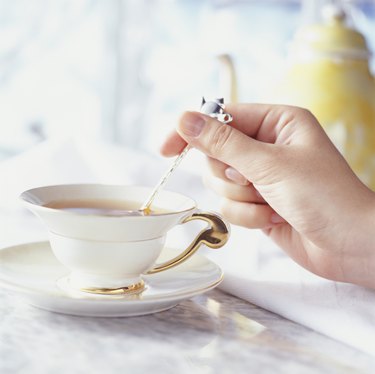 女人用茶匙搅茶，手部特写，(特写)