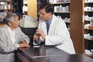 Senior woman talking with pharmacist in pharmacy