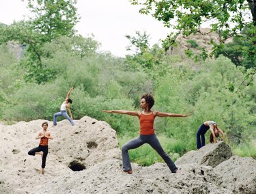 Women doing yoga positions on rocks