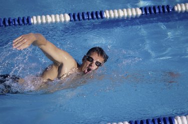 Side profile of a young man swimming in a swimming pool