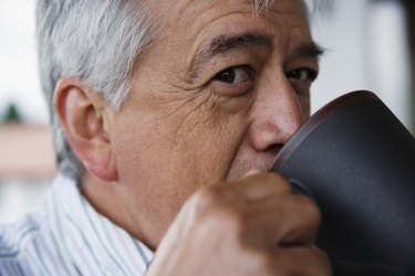 Close up profile of elderly man drinking coffee