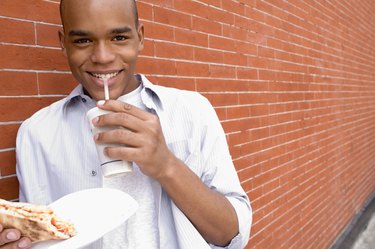 Smiling man with pizza and beverage