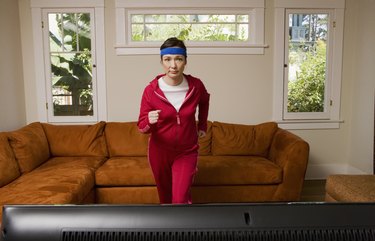 Woman exercising in front of television