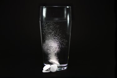 Dissolving tablet into glass of water