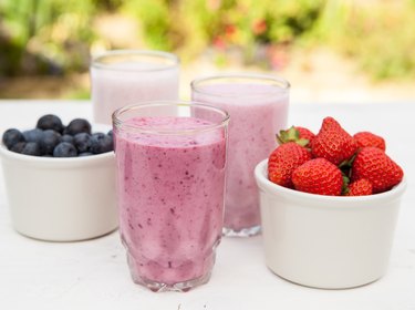 Three small glasses of smoothie on the white table