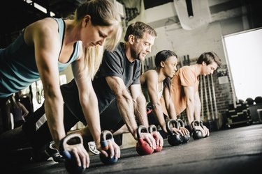 People doing a HIIT workout using kettlebells in a gym