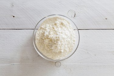 Flour in a bowl on wooden table