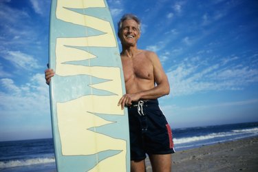 Senior man holding a surfboard