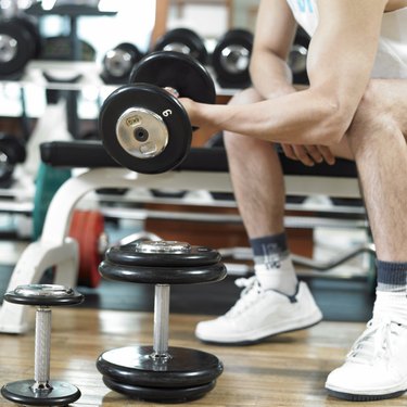 a man exercising with dumbbells at a fitness club