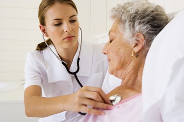 Nurse checking woman's heartbeat