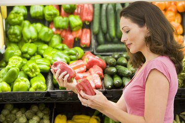Woman shopping for bell peppers at a grocery store