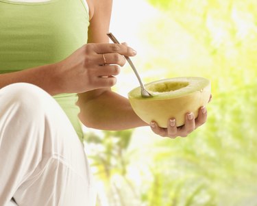 Hispanic woman eating melon