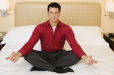 Man meditating in hotel room