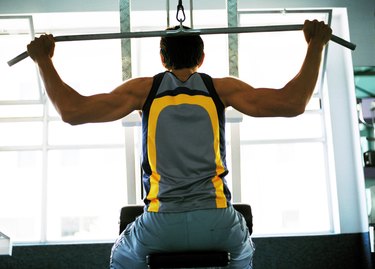 Rear view of a young man exercising on an exercise machine