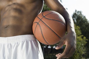 A man holding a basketball, midsection