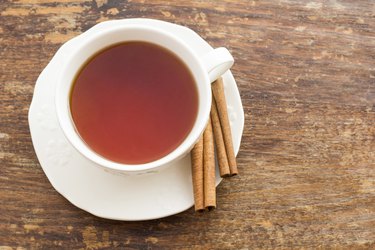 Cup of tea with cinnamon on a wooden surface